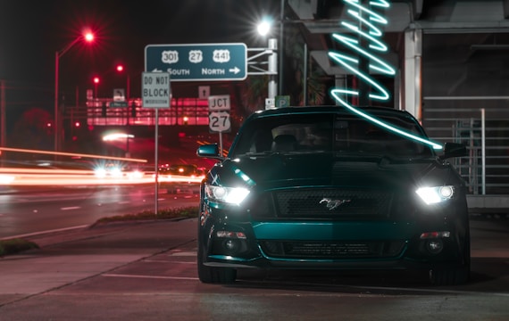 a car parked on the side of the road at night