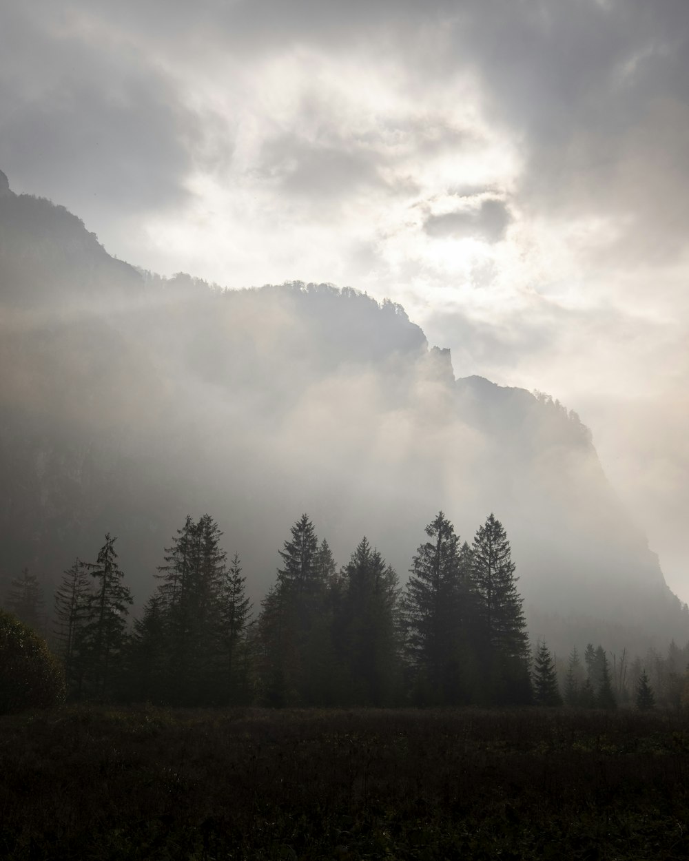 the sun shines through the clouds in the mountains