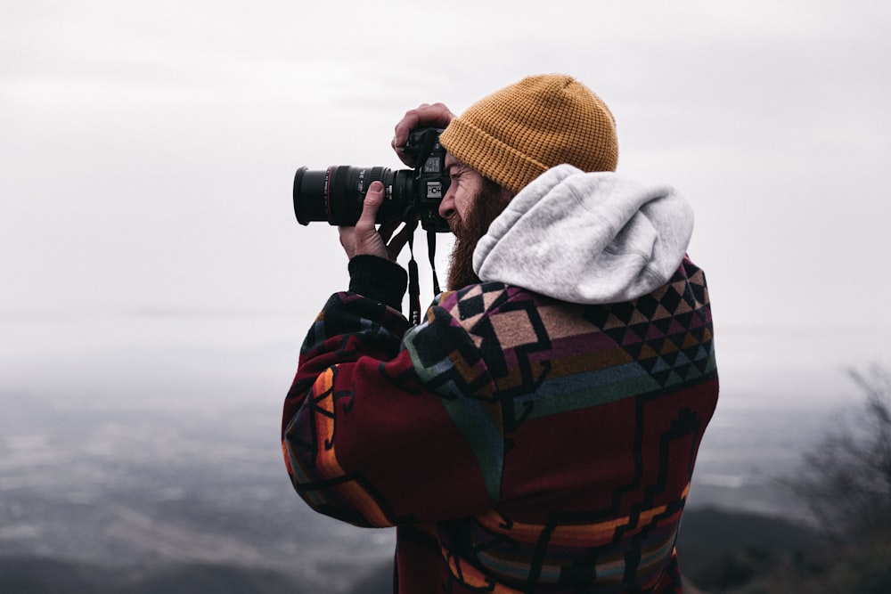 person in gray hoodie using black binoculars