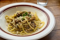 Spaghetti tossed in a creamy mushroom sauce, garnished with fresh parsley on a wooden table.