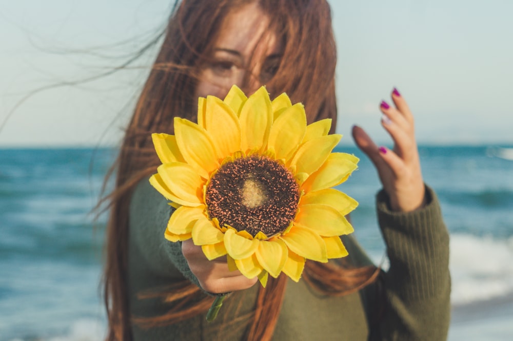 woman holding sunflower during daytime