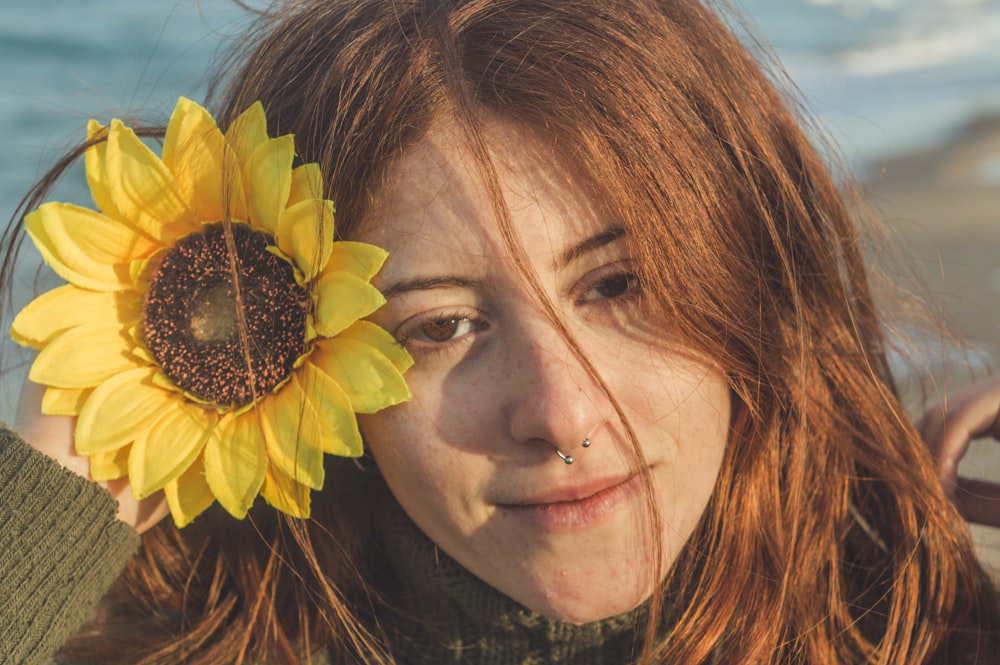 woman with yellow sunflower on her ear