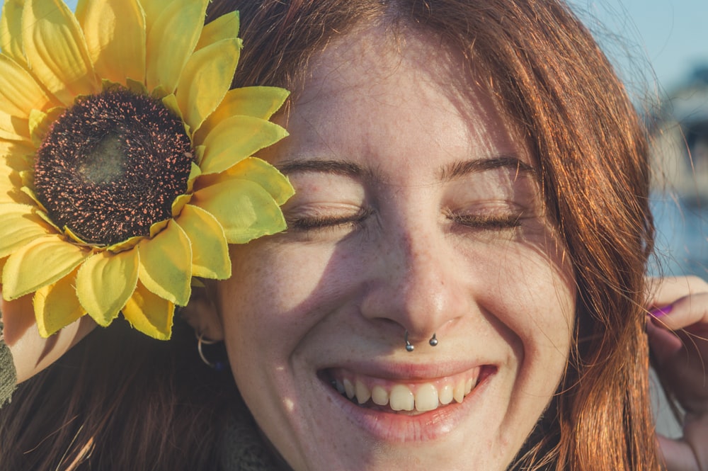 femme avec une fleur jaune sur son oreille