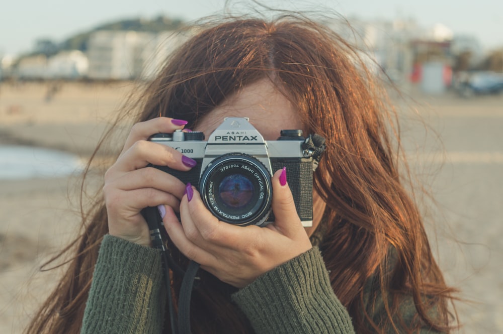 woman holding black and silver nikon dslr camera