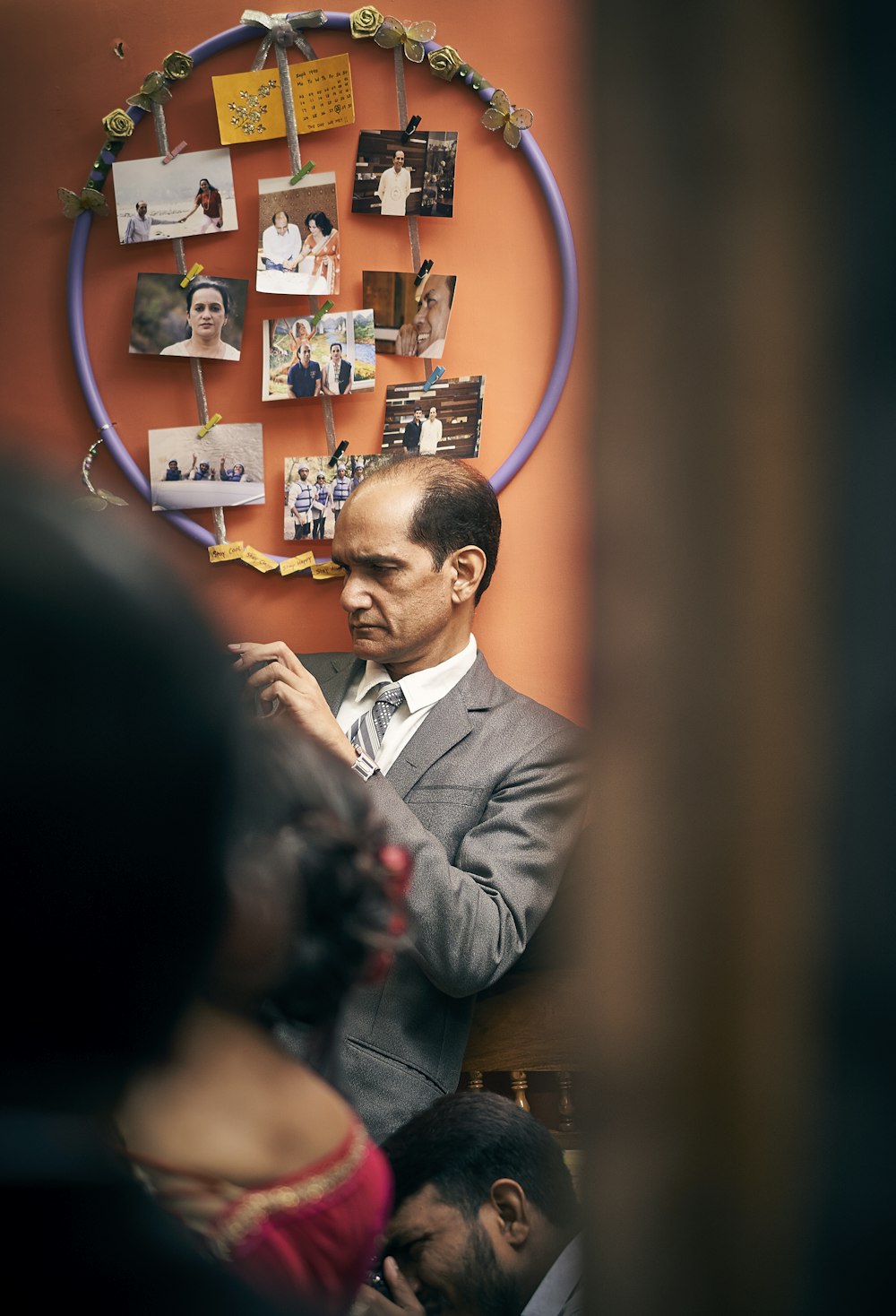 a man standing in front of a wall with pictures on it