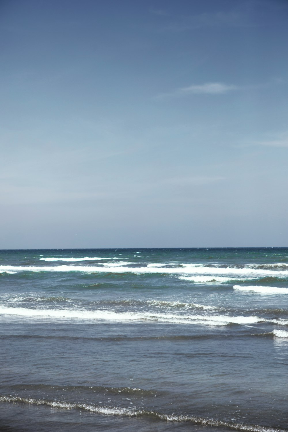 ocean waves under cloudy sky during daytime