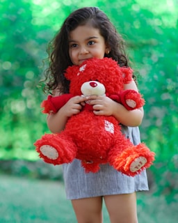 A child hugging a large, fluffy teddy bear.