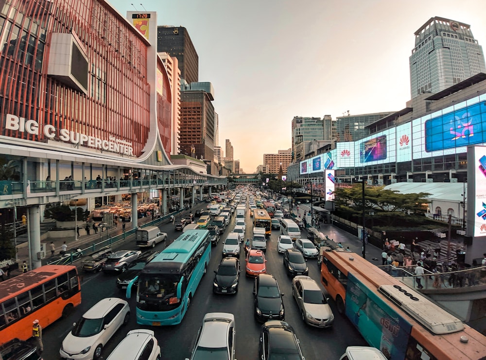 cars parked on side of the road in between high rise buildings during daytime