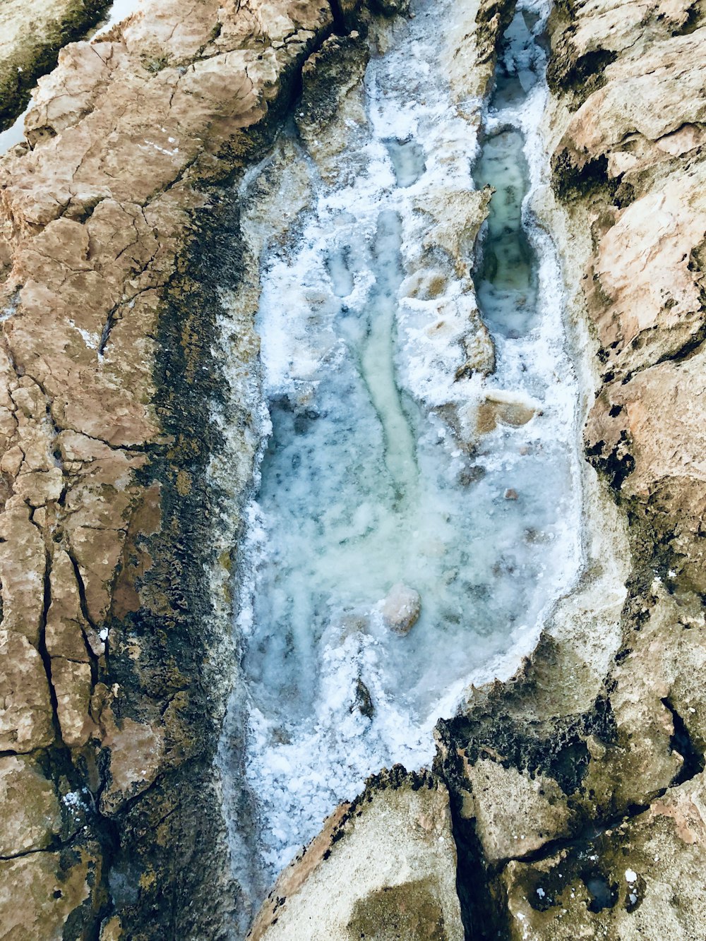 brown rock formation with water