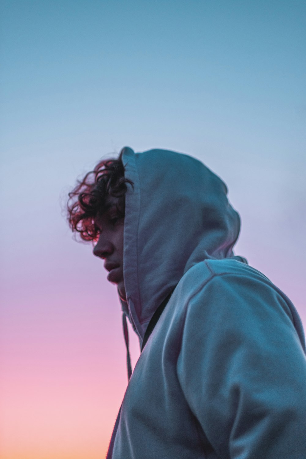 man in green hoodie looking down