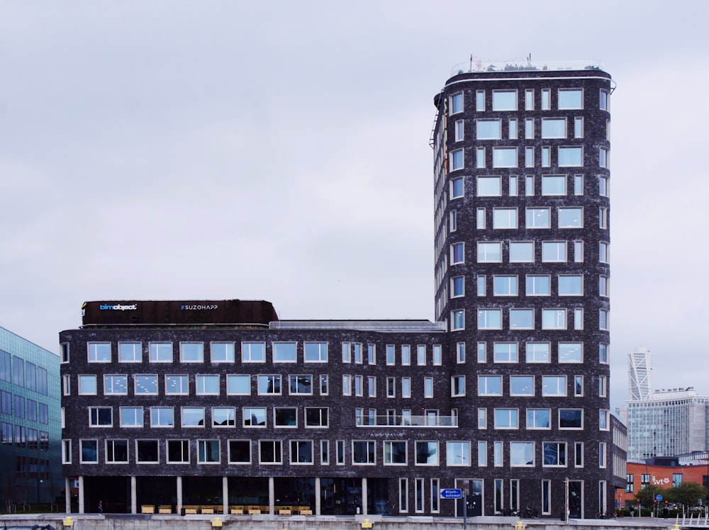 a tall building with lots of windows next to a body of water