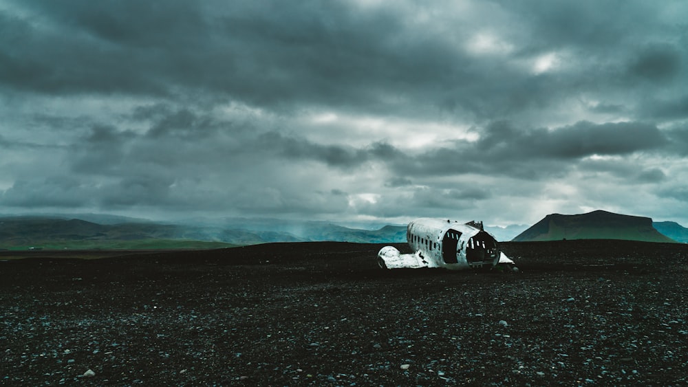 white car on black sand under gray cloudy sky