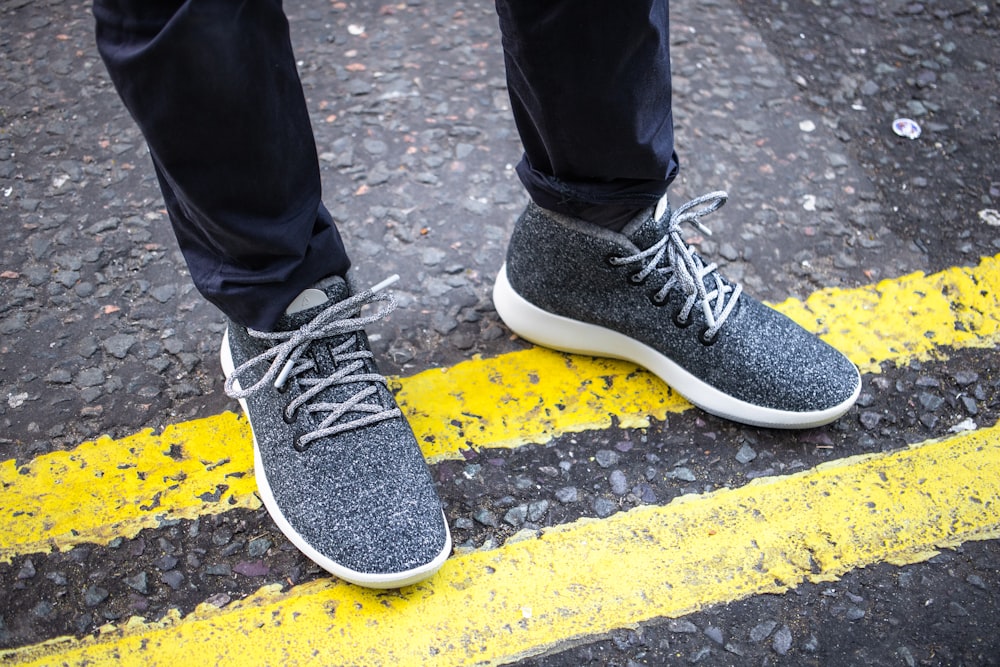 a person standing on a street with their feet on the ground