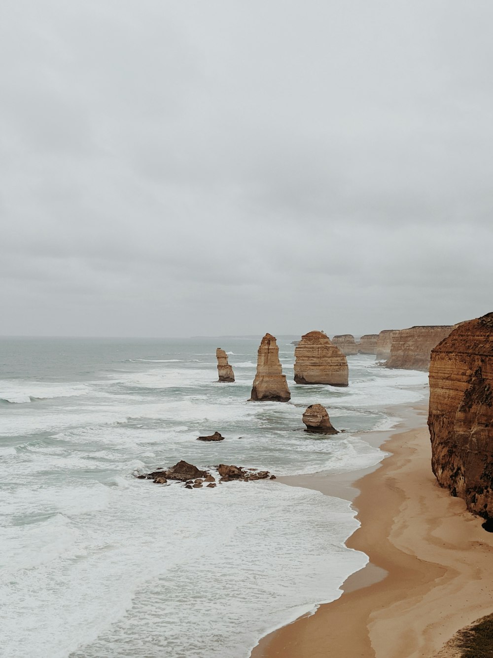 a view of a beach with a few rocks in the water