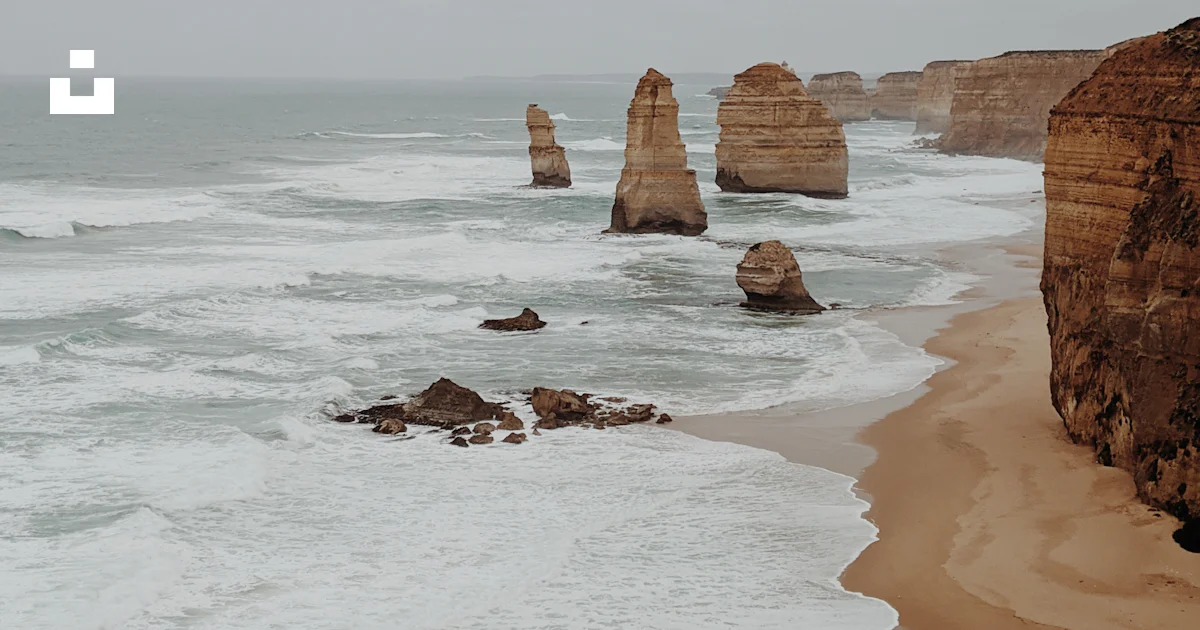 A view of a beach with a few rocks in the water photo – Free Nature ...