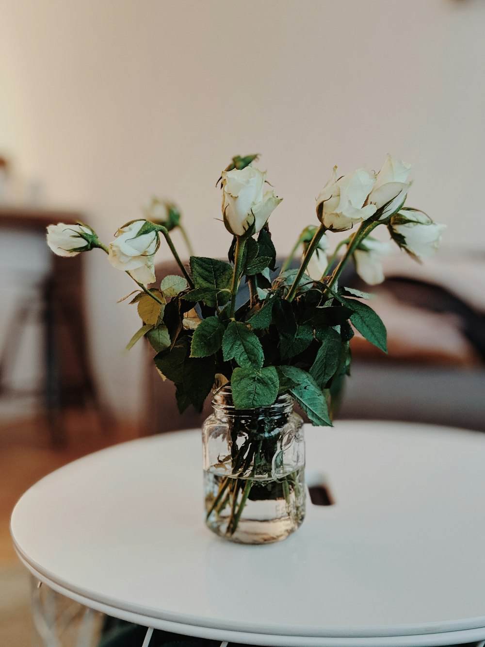 a glass vase with white flowers on a table