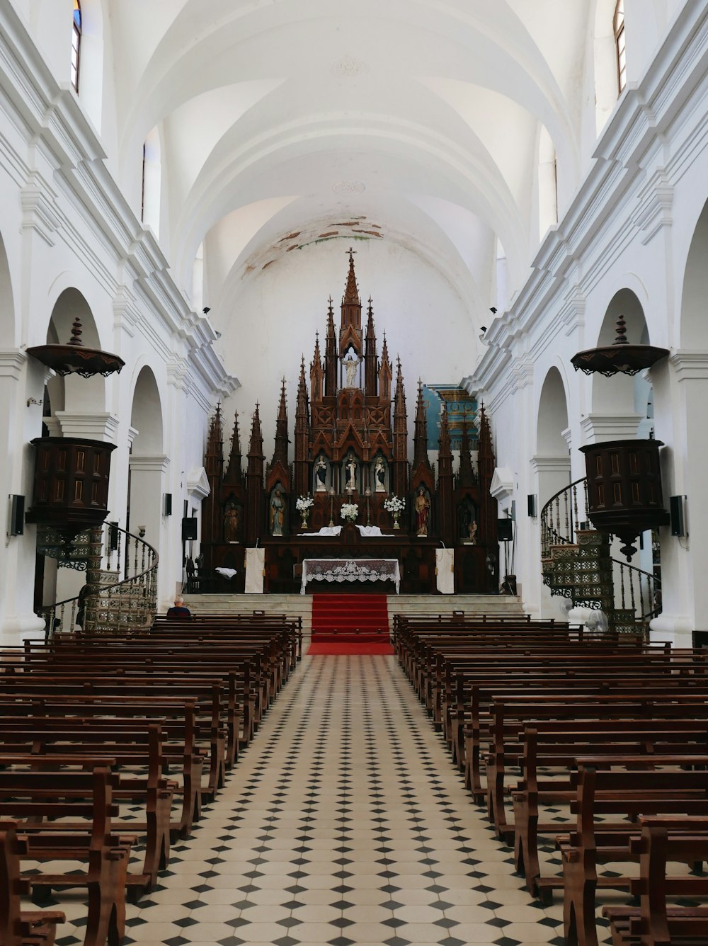 eine Kirche mit einem karierten Boden und einem großen Altar