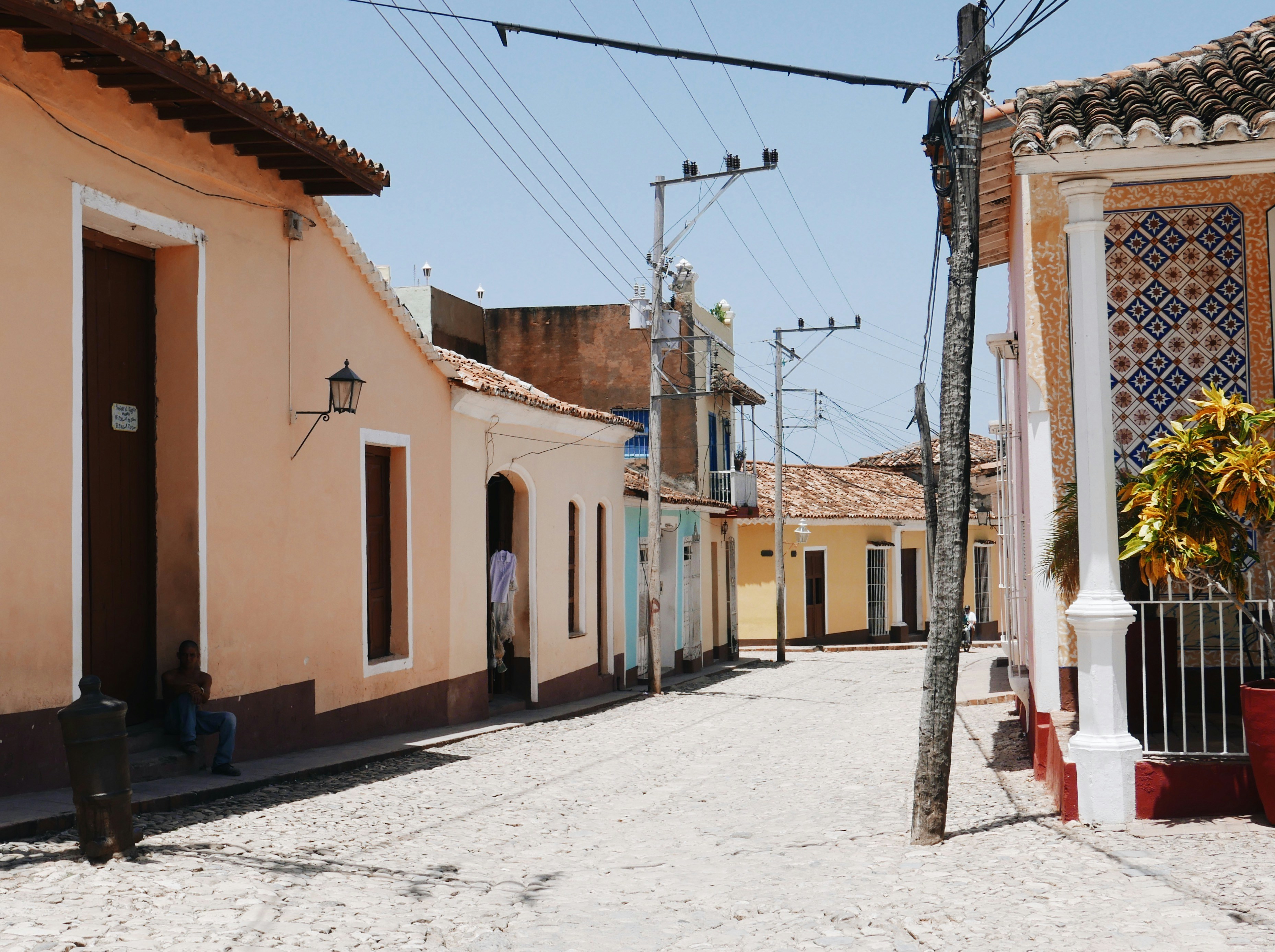 a street with a few buildings and a person sitting on a bench