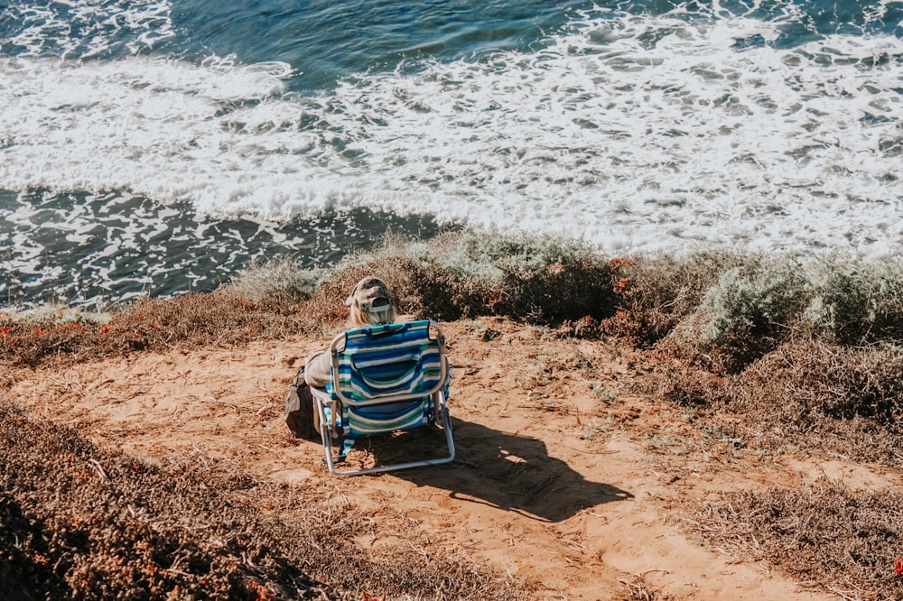 a person sitting in a chair on the beach