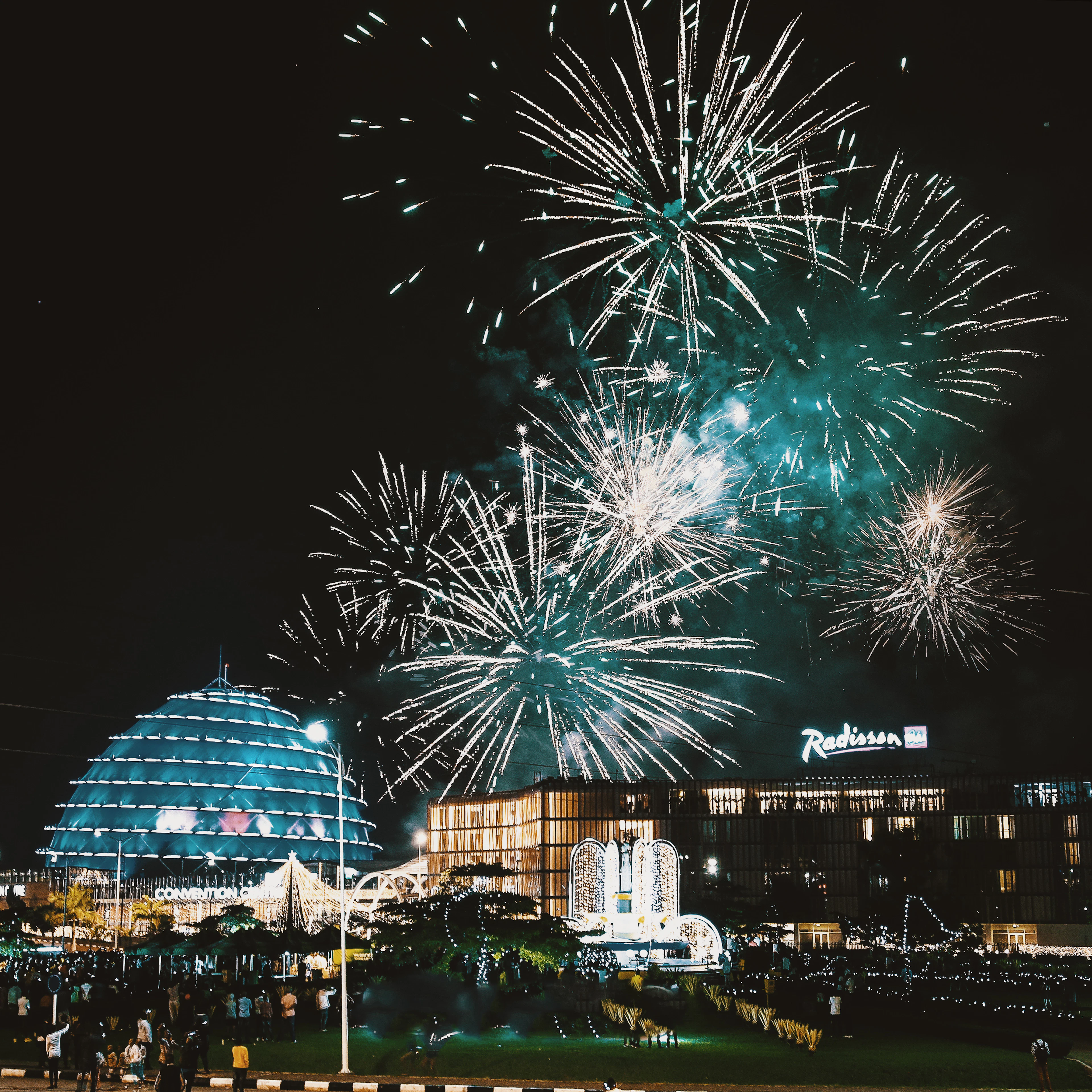 Fireworks bursting over the illuminated dome of the Kigali Convention Centre and the Radisson Blu hotel at night