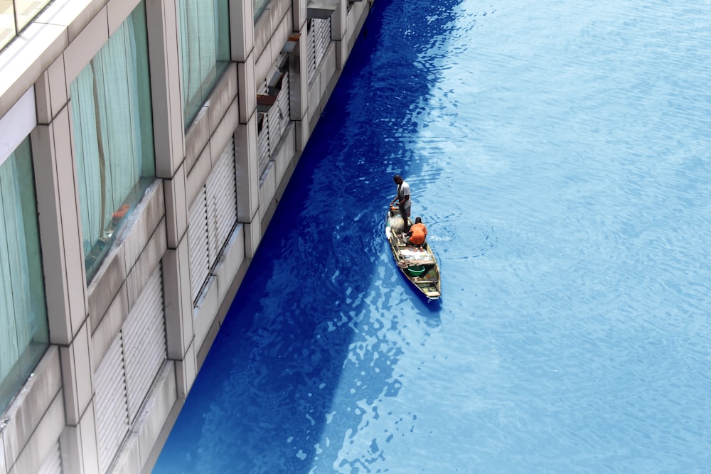 man in black shirt riding on blue and white boat on blue water