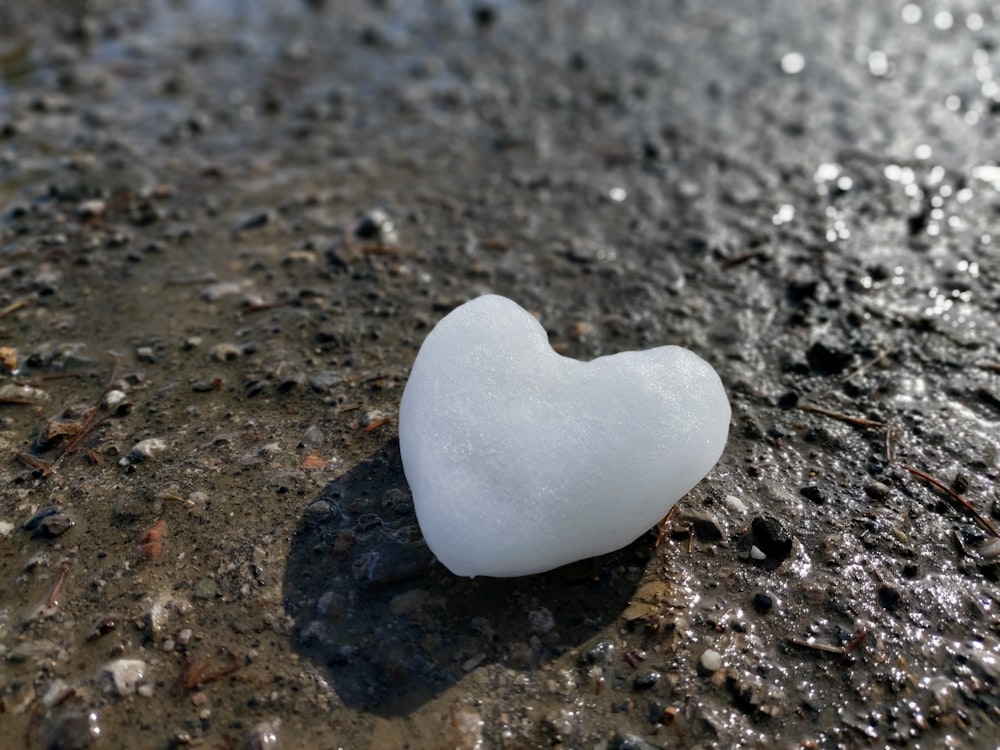 white heart shaped stone on black sand