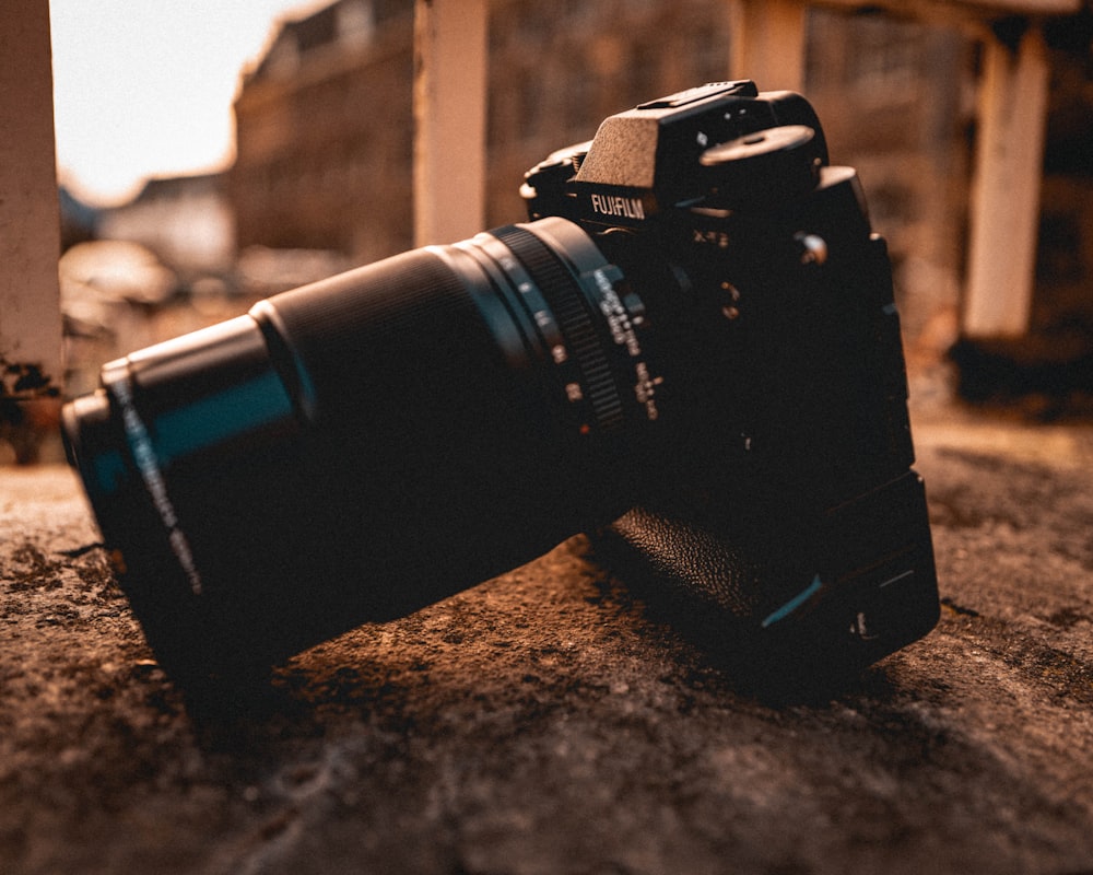 black nikon dslr camera on gray concrete floor