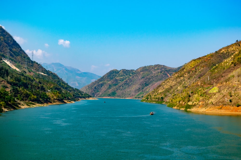 green mountains beside body of water during daytime