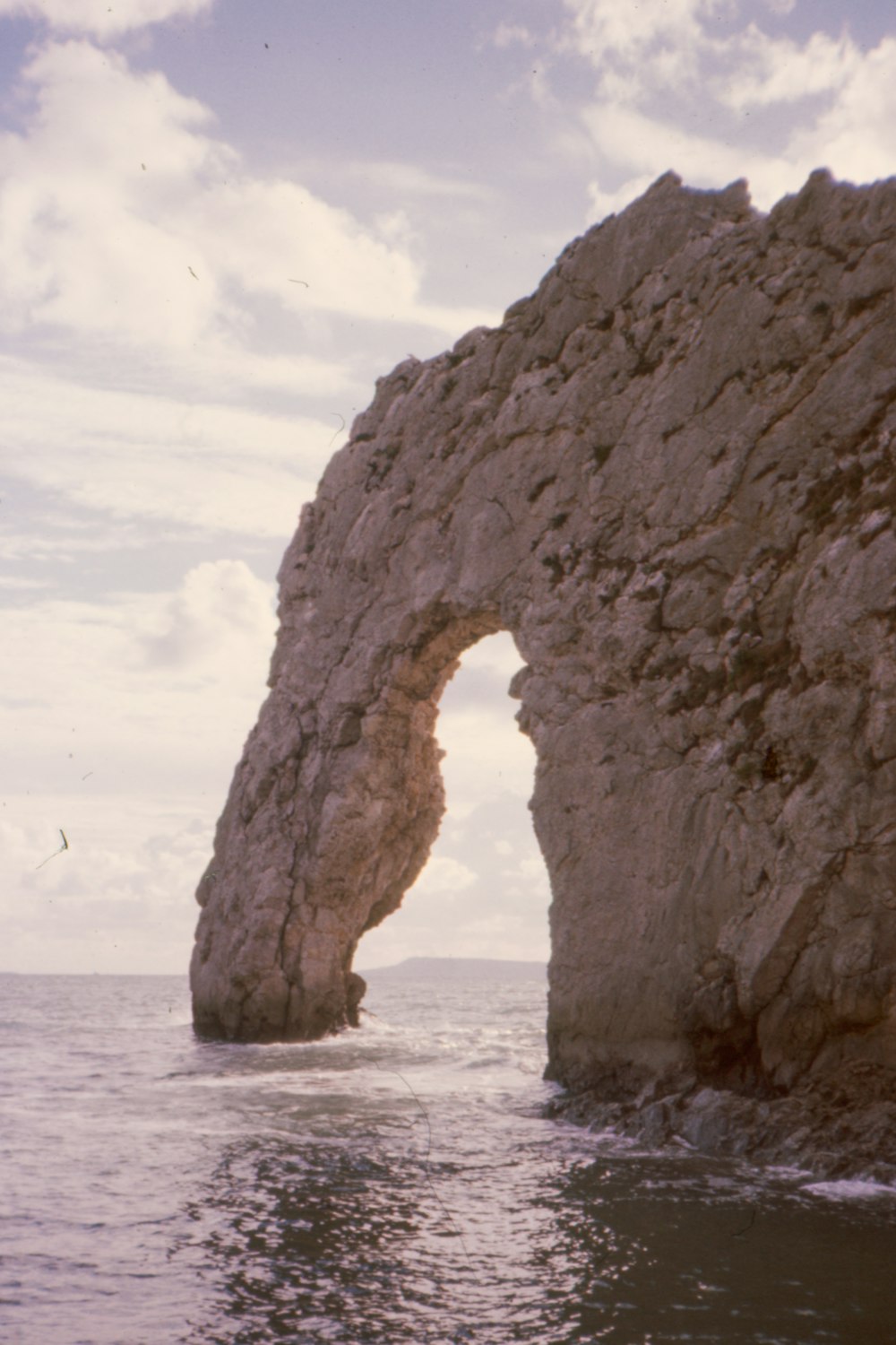 a large rock formation in the middle of the ocean