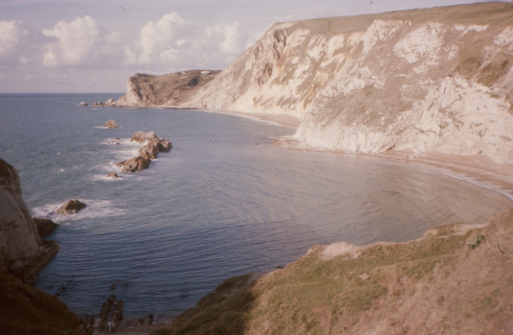 a body of water near a rocky cliff