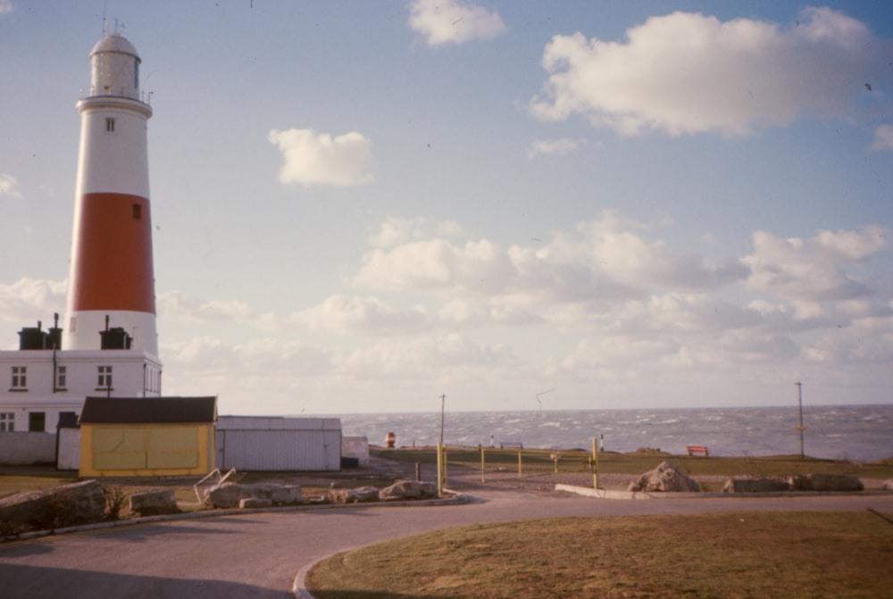 a light house on the side of a road near the ocean