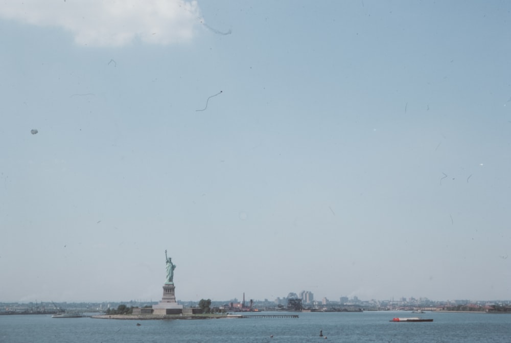 the statue of liberty stands in the middle of the water