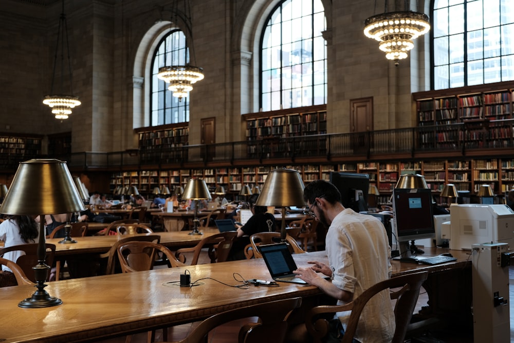 a woman sitting at a table in a library