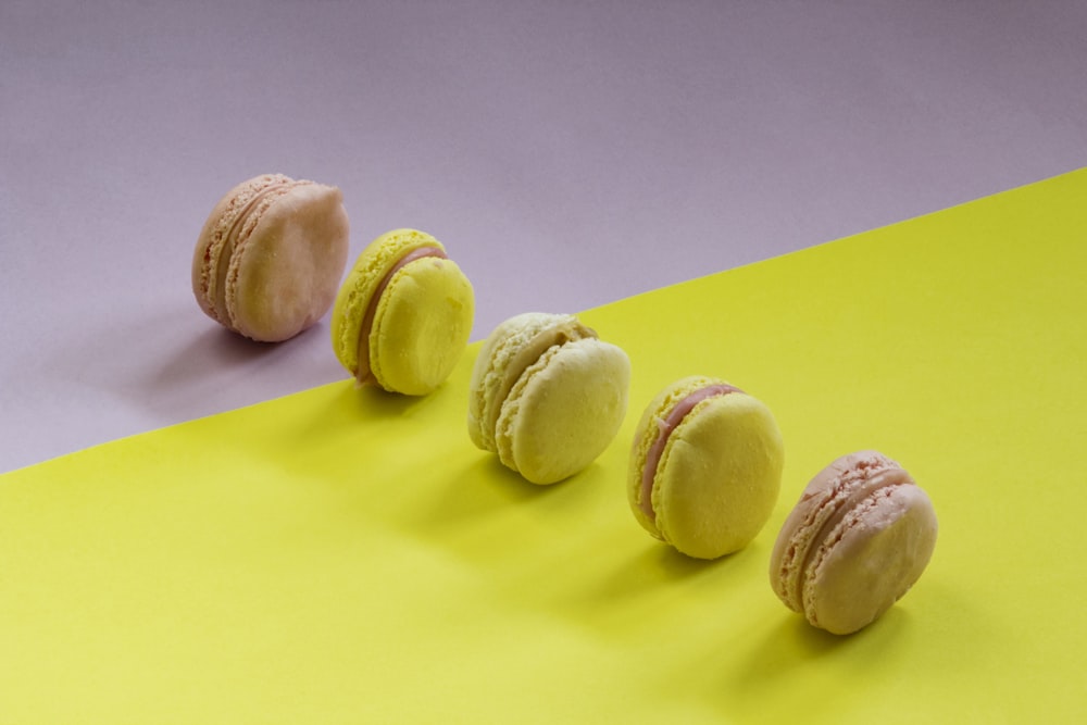 a row of macaroons sitting on top of a yellow and purple surface