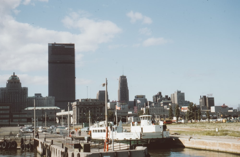 a boat docked in a harbor with a city in the background