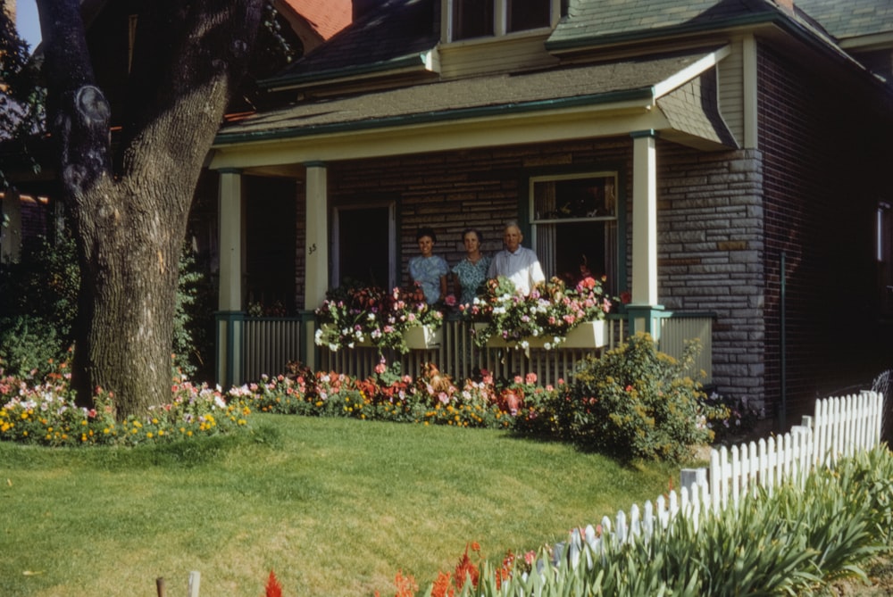a couple of people that are standing in front of a house
