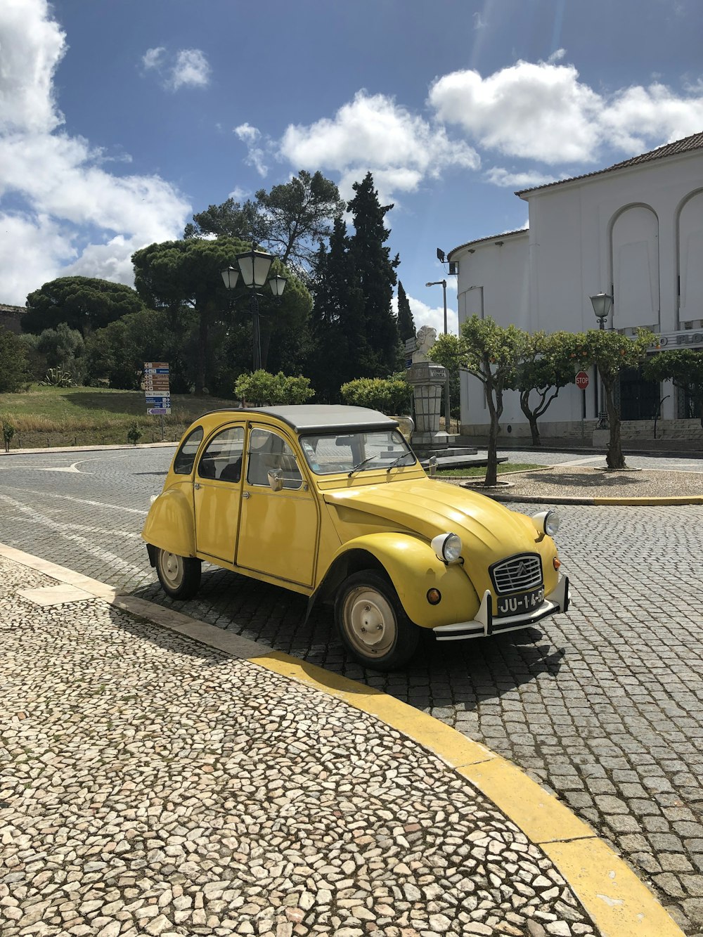 yellow volkswagen beetle parked on side of the road during daytime