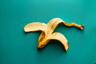 a peeled banana sitting on top of a green surface