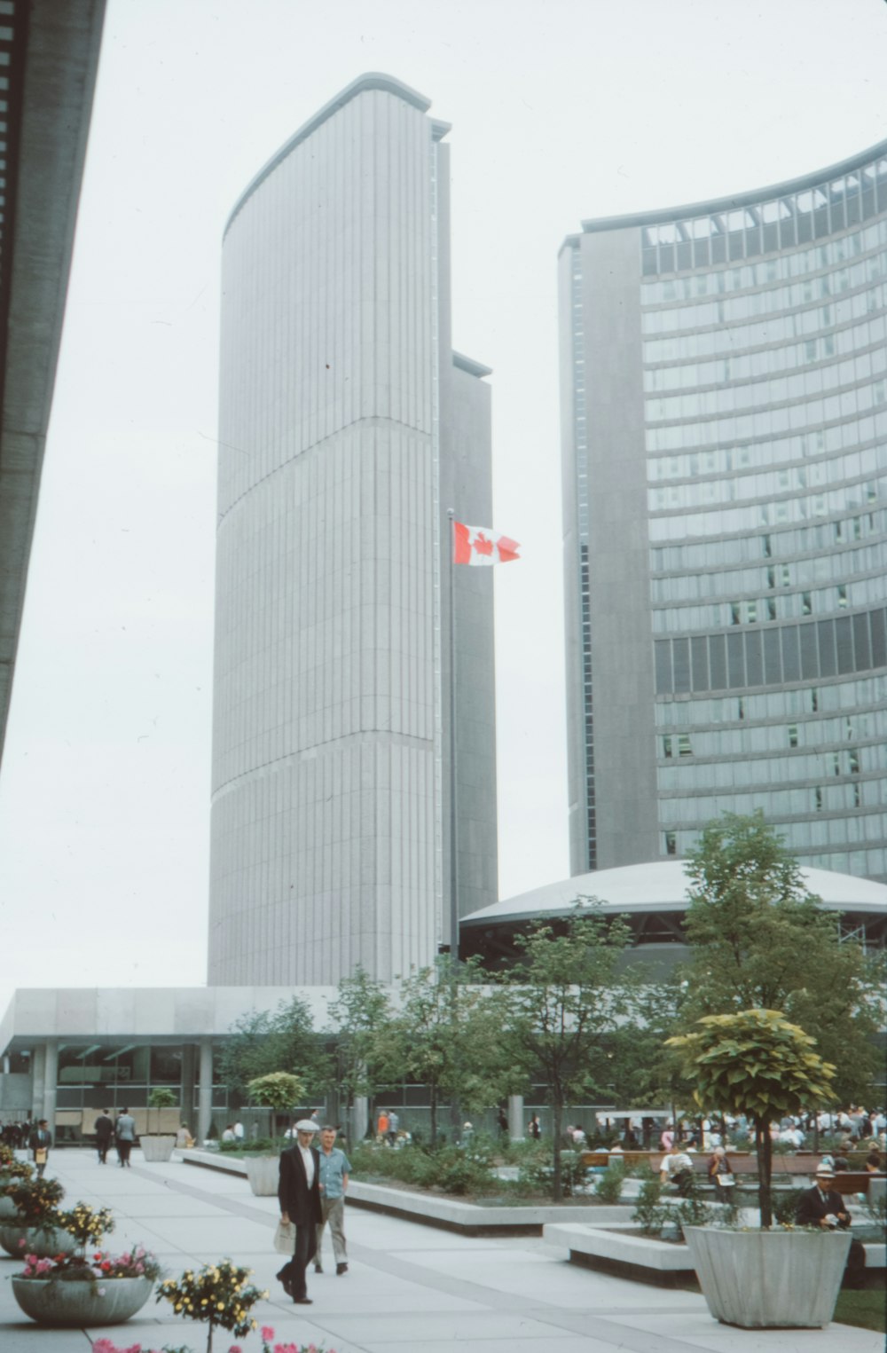 a man in a suit and tie walking in front of a tall building