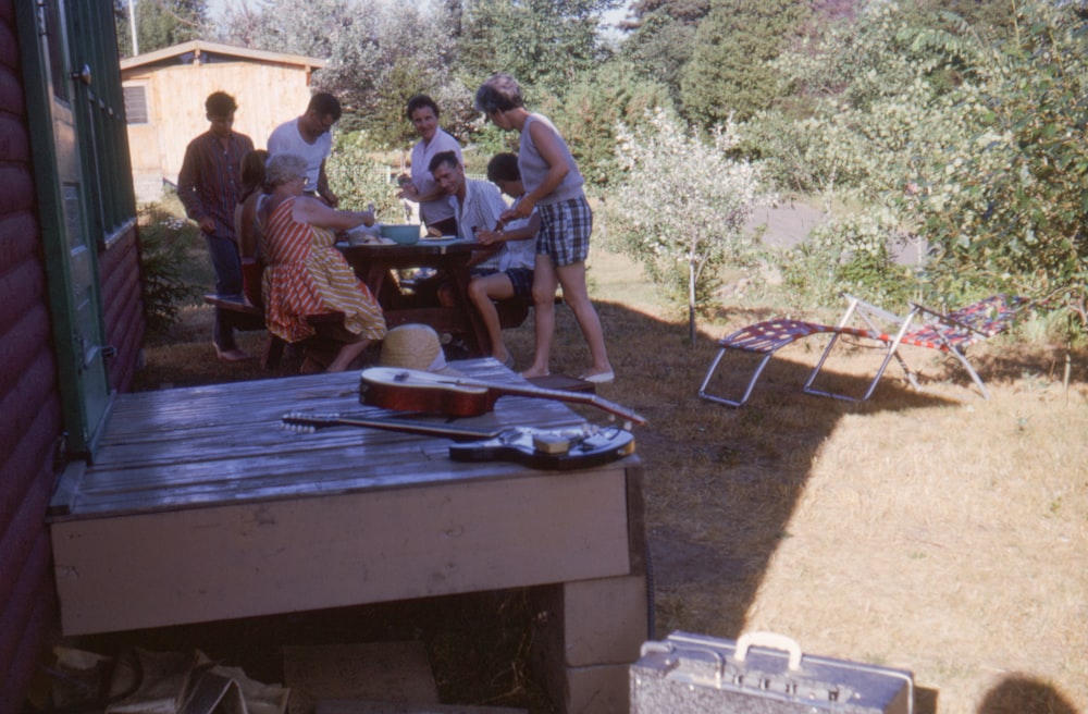 a group of people standing around a picnic table