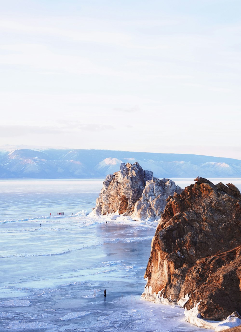 brown rock formation on sea under white sky during daytime