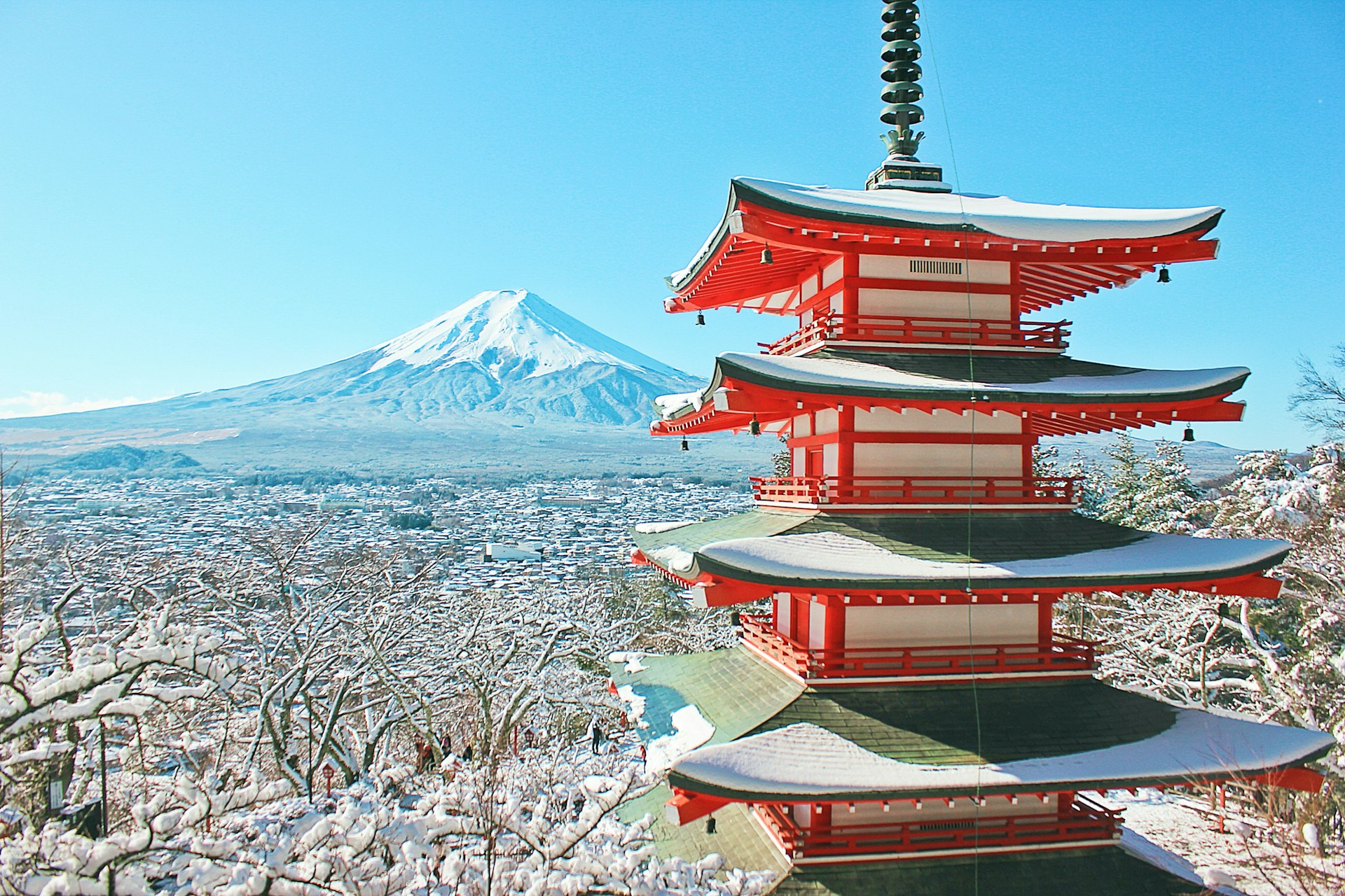 red and white pagoda temple near snow covered mountain during daytime