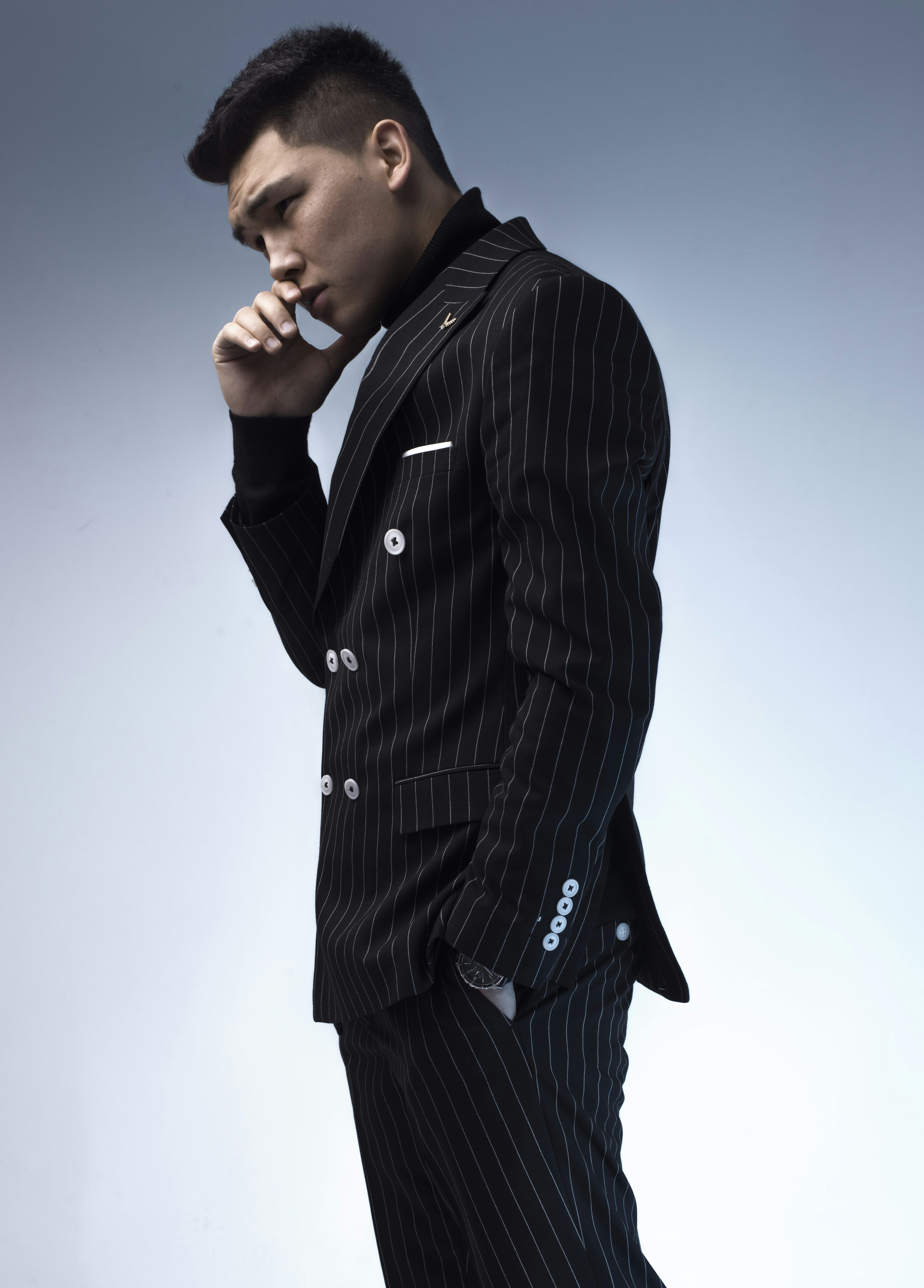 a man in a pinstripe suit smoking a cigarette