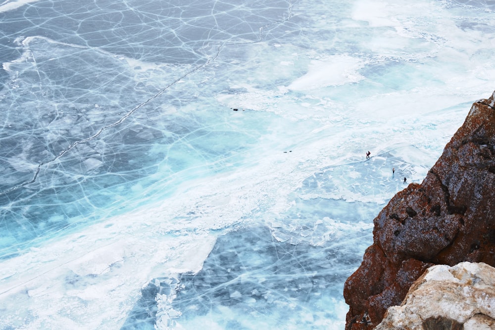 person in black jacket standing on brown rock formation during daytime