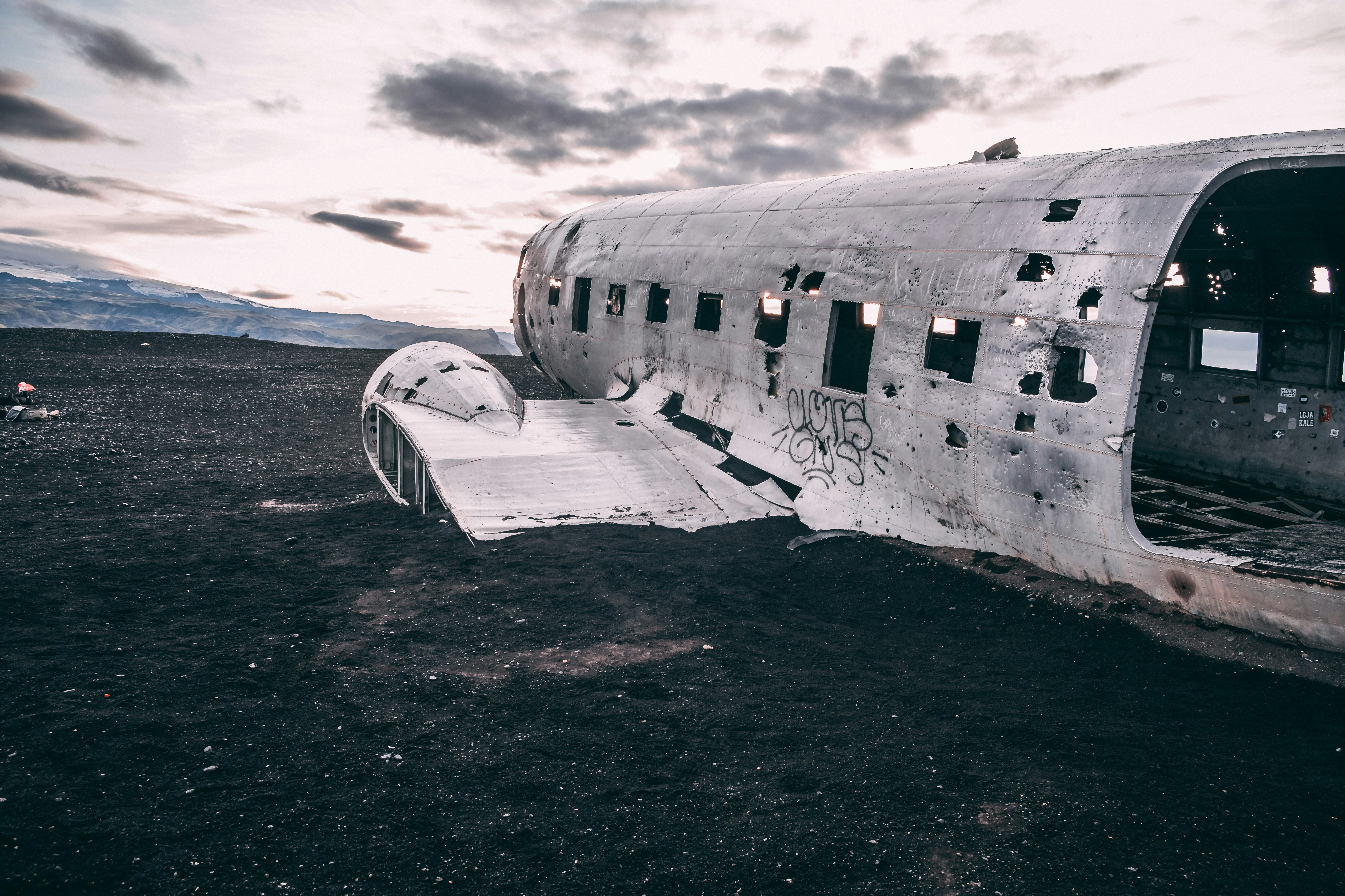 white airplane on black sand during daytime