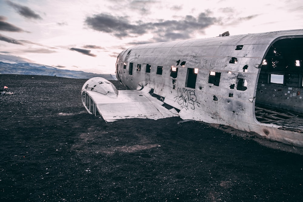 aeroplano bianco su sabbia nera durante il giorno