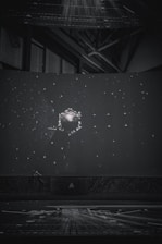 Children sitting inside a portable planetarium dome, gazing up at a star-filled sky projection.