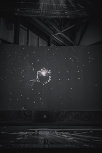 Children sitting inside a portable planetarium dome, gazing up at a star-filled sky projection.