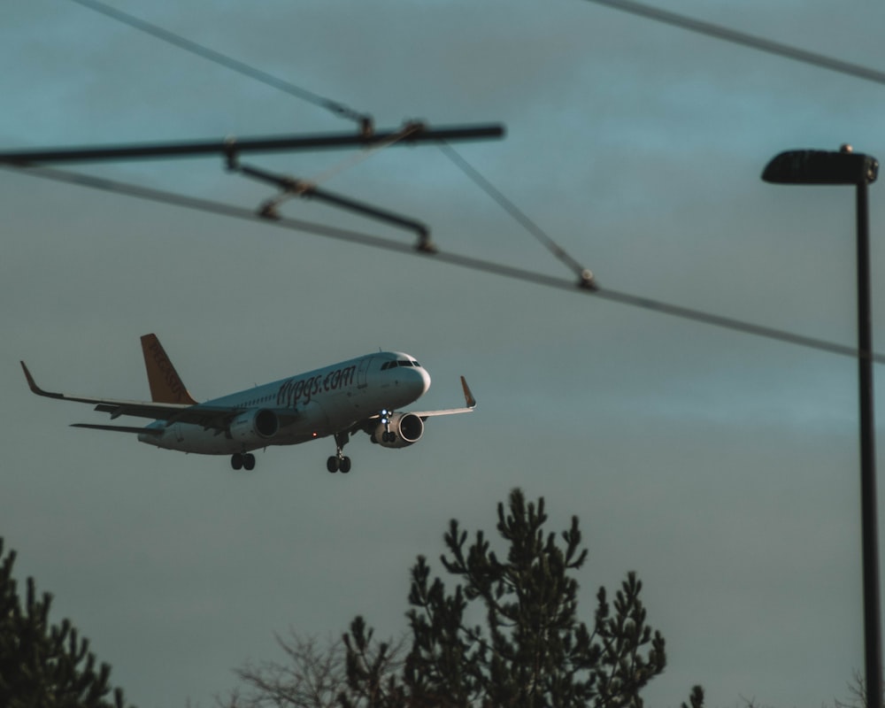 white and blue passenger plane flying during daytime