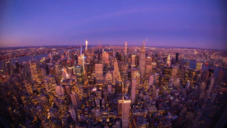 An aerial view of a vibrant city skyline during twilight.